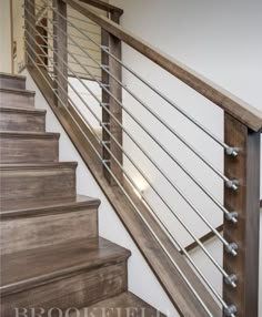 a wooden stair case with metal handrails