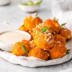 a white plate topped with fried food and dipping sauce