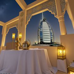 a table with a white cloth on it in front of a view of the burj al arab