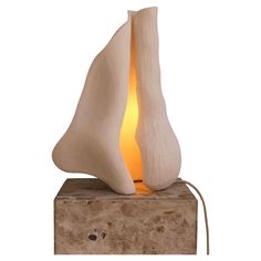 a light that is sitting on top of a block of wood and has a small candle in it