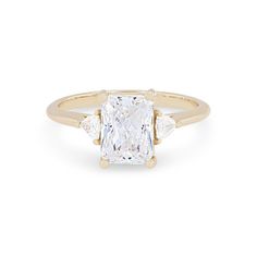 a yellow gold ring with an oval cut diamond and three baguets on the band