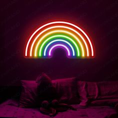 a bed with a rainbow light on the wall above it