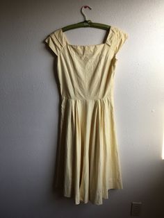 "1950s handmade sun dress yellow cotton w/very subtle leaf motif print sleeveless pullover wide pleated shoulder straps square neck/back fitted top w/breast darts side zipper pleated waist good vintage condition, light wear light rust color stains here and there measures, lying flat, shoulder-20\" bust-18 3/4\" (37 1/2\" total) waist-14\" (28\" total) top shoulder to waist-16 1/2\" total length-44\"" Spring Cotton Dress With Pleated Bodice, Classic Cotton Summer Dress, Fitted Cotton Cream Dress, Solid Color Vintage Cotton Dress, Fitted Cream Cotton Dress, Solid Color Vintage Summer Dress, Retro Summer Dress With Box Pleat, Spring Cotton Dress With Cap Sleeves, Fitted Casual Dress For Vintage Fashion