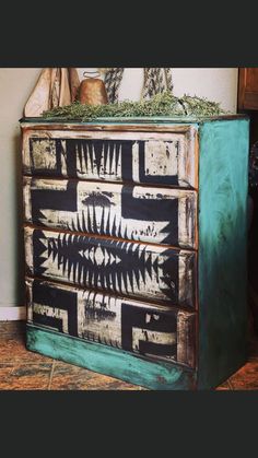 an old dresser is painted with black and white designs