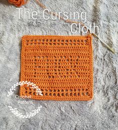 an orange crochet square sitting on top of a blanket