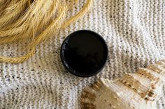 a black bowl sitting on top of a white blanket next to a sea urchin