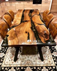 a table made out of wood with leather chairs around it and an area rug on the floor