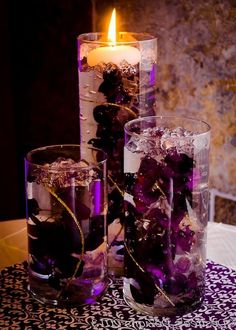 two tall vases filled with flowers on top of a table