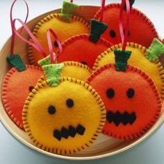 four oranges with faces on them in a bowl