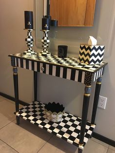 a black and white checkered console table with candles on the shelf next to it