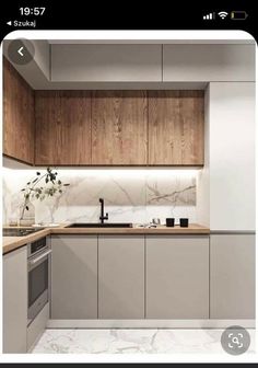 a modern kitchen with marble counter tops and wooden cabinetry, along with white walls