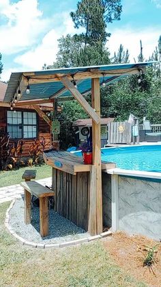 an outdoor bar next to a swimming pool with a grill and picnic table in the foreground