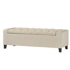 an upholstered bench with wooden legs and tufted seat cushion on the back