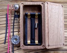 a wooden box filled with tools on top of a wood table next to other items