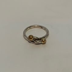 Previously Loved Tiffany & Co 18k Gold & 925 Sterling Silver Vintage Knot Ring. Simple & Elegant - Made Of Sterling Silver & Accented W/Yellow Gold Balls. 100% Authentic. This Design Has Not Been In Tiffany & Co. Production For Many Years, Was Fashioned Back In 70's & Is A Classic. Knot Symbolizing Friendship, Family & Love. Perfect Gift For A Special Loved One & Unisex. Ring Size 5 Both Stamped: Tiffany & Co 925 750 Tiffany And Co Earrings, Tiffany And Co Bracelet, Tiffany Diamond, Padlock Necklace, Open Heart Necklace, Toggle Necklace, Heart Choker, Ring Simple, Knot Ring