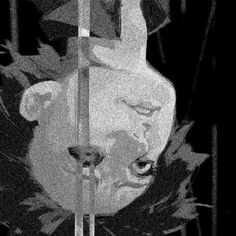 a black and white photo of a teddy bear on a pole with leaves around it