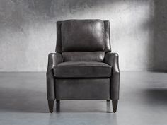 a gray leather chair in an empty room