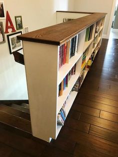 the bookshelf has many different types of books on it and is next to a staircase