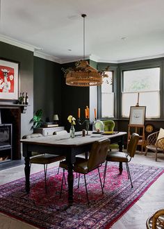 a dining room table with chairs and a rug in front of the fire place,