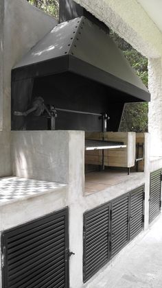 an outdoor bbq with grills on the side and doors open to let in light