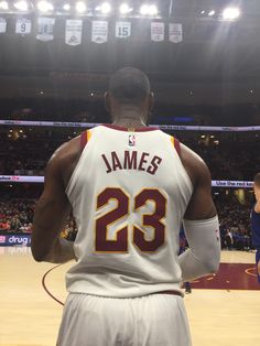 the back of a basketball player's jersey in front of an arena filled with fans