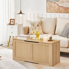 a living room with a couch, coffee table and two candles on the end tables