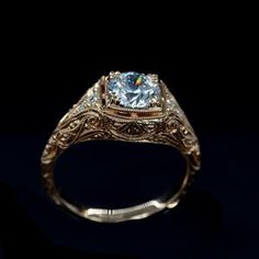 an antique style engagement ring with a blue topazte center stone