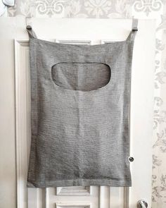 a gray and white striped bag hanging on the wall next to a radiator