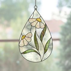 a stained glass window with flowers hanging from it