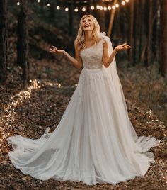 a woman in a wedding dress is laughing and holding her arms out to the side