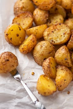 Cooked air fried baby potatoes on parchment paper with one potato stabbed with a fork. Air Fried Yellow Potatoes, Air Fried Mini Potatoes, Airfryer Mini Potatoes, Air Fryer Little Potatoes, Little Potatoes In Air Fryer, Mini Yellow Potatoes Recipes, Yellow Potatoes Recipes Air Fryer, Small Golden Potatoes Recipes, Small Yellow Potatoes Recipes