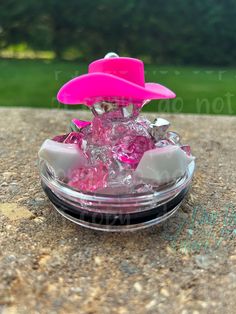 a small pink object sitting on top of a rock