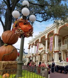 the halloween decorations are on display in front of an old building with pumpkins hanging from it's roof