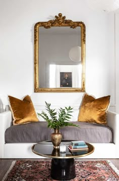 a living room filled with furniture and a large mirror on the wall over a coffee table