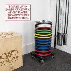 a stack of colorful plates sitting on top of a black floor next to a box