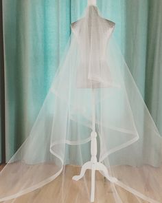 a bridal veil sitting on top of a mannequin's head in front of a curtain