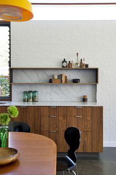 a dining room table with chairs and shelves