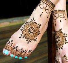 two feet with henna tattoos on them, one is blue and the other is brown