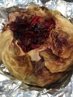 an artichoke is wrapped in foil and ready to be cooked on the grill