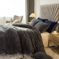 a bedroom with a large bed covered in grey blankets