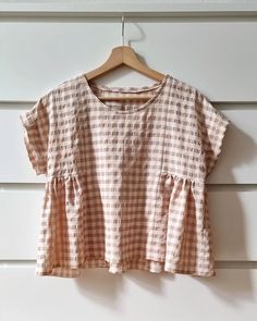 a brown and white checkered top hanging on a wall