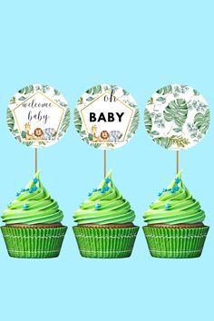 three cupcakes with green frosting on top and one has a welcome baby sign