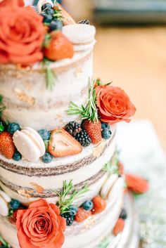 a multi layer cake with fresh fruit and flowers on top