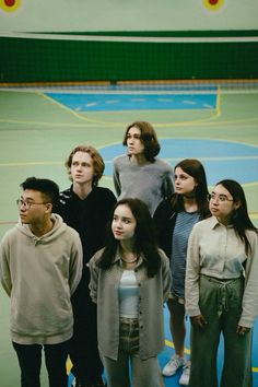 a group of young people standing on top of a basketball court next to each other