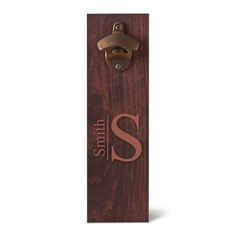 a wooden door handle with the letter s on it and a bell in the middle