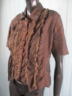 Very pretty chocolate brown ruffled blouse with short sleeves and a lace front. It has a collar and small silver buttons down the front. Dimensions: Bust: 40 Inches. Length: 21 Inches. Made in France