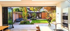 an open kitchen and living room area with sliding glass doors leading to the back yard