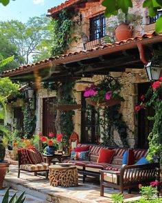 an outdoor living area with couches and potted plants