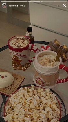 popcorn, hot chocolate and marshmallows on a glass table with candy canes