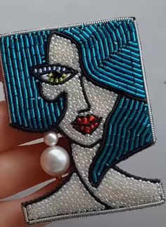 a woman's face is depicted on a piece of fabric with pearls in her hand